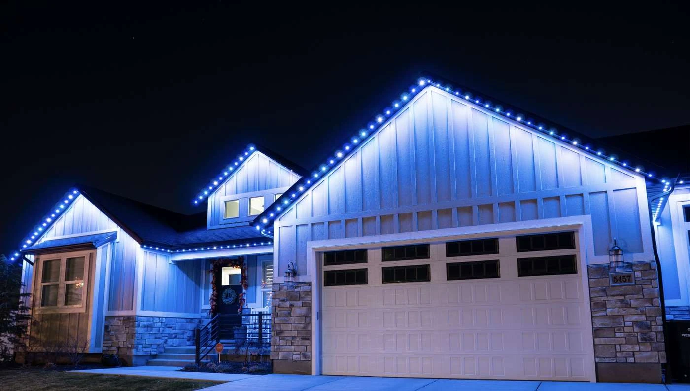 permanent LED lights illuminating a home roofline in blue